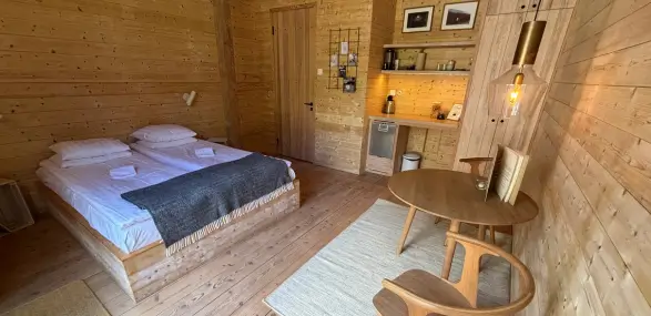 Schönes Zimmer mit King-Size-Bett im skandinavischen Stil aus Holz eingerichtet.