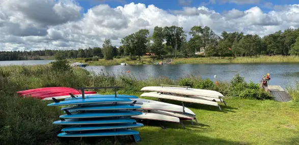 Viele Kajaks im Ragö Naturreservat liegen neben dem Wasser auf der Wiese
