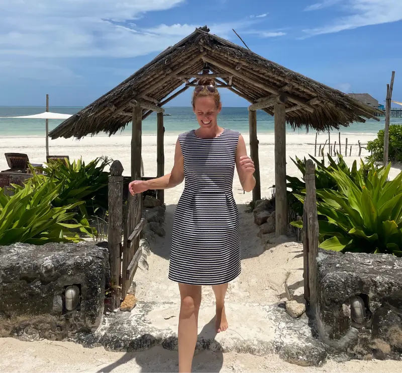 CEO Lisa Weddig von Local Vibes Yoga Retreats geht lachend über den Strand auf Sansibar