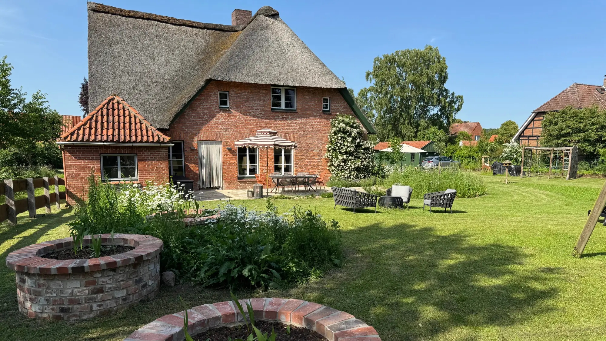 Außenansicht Reetdachhaus The Betterheim mit großem Garten